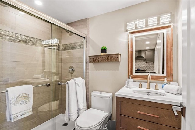 bathroom with walk in shower, vanity, and toilet