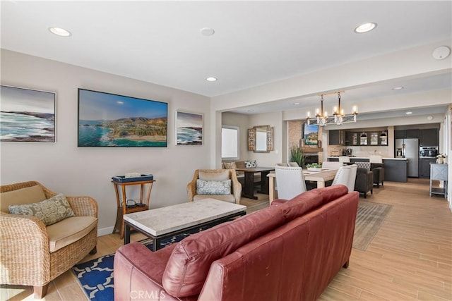 living room with an inviting chandelier and light hardwood / wood-style flooring