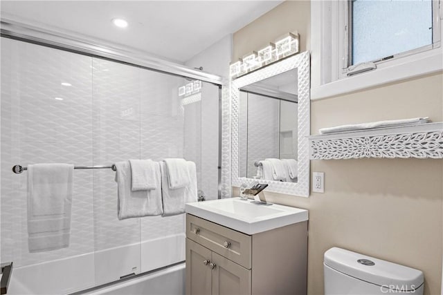 full bathroom with toilet, vanity, and bath / shower combo with glass door