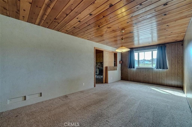 carpeted empty room with wooden ceiling