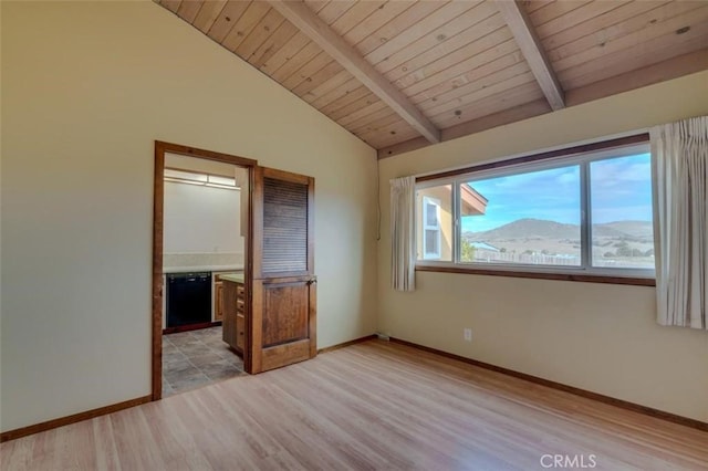 unfurnished bedroom with lofted ceiling with beams, a mountain view, wooden ceiling, and light hardwood / wood-style flooring