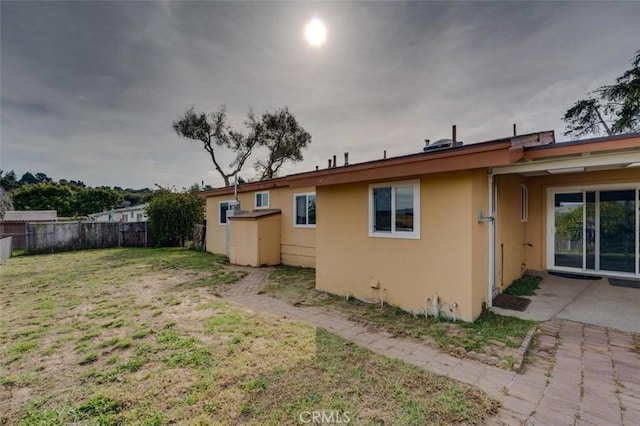 back of property featuring a patio and a yard