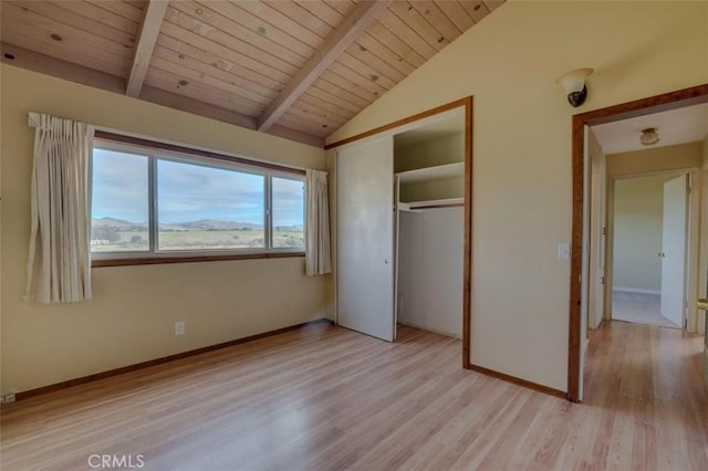 unfurnished bedroom with a closet, lofted ceiling with beams, light hardwood / wood-style flooring, and wooden ceiling