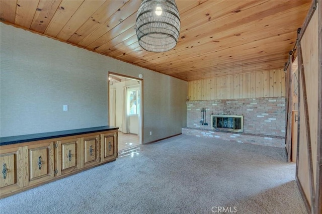 unfurnished living room with a brick fireplace, light colored carpet, and wooden ceiling