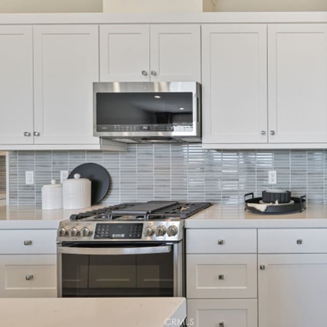 kitchen with tasteful backsplash, stainless steel appliances, and white cabinets