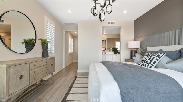 bedroom featuring ensuite bathroom and light wood-type flooring