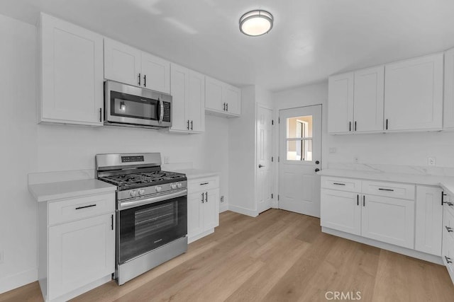 kitchen featuring light hardwood / wood-style flooring, white cabinets, and appliances with stainless steel finishes