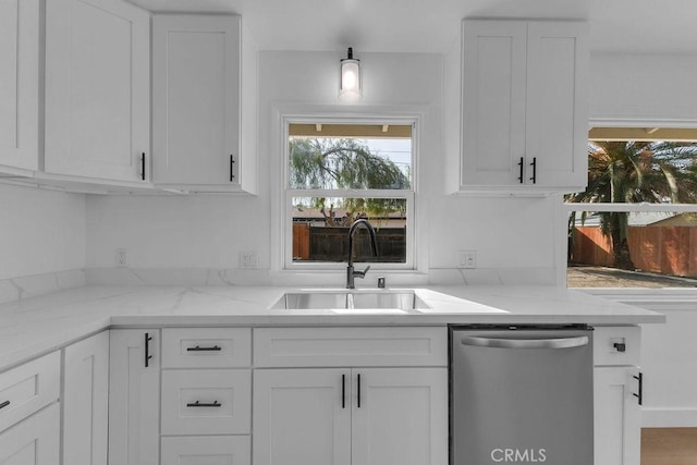 kitchen featuring dishwasher, sink, and white cabinets