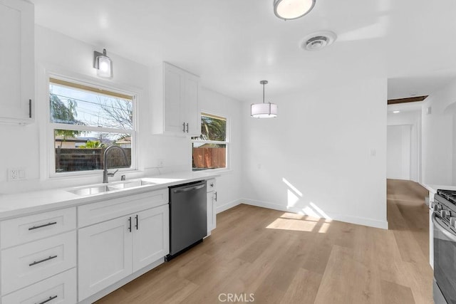 kitchen with sink, white cabinetry, hanging light fixtures, light wood-type flooring, and appliances with stainless steel finishes