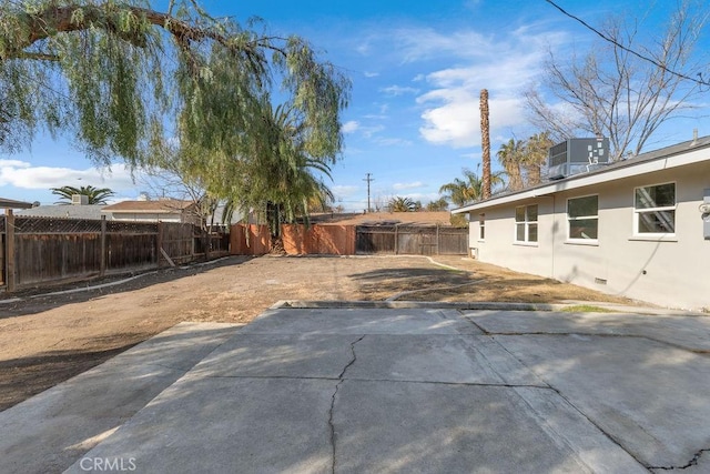 view of yard featuring central AC unit and a patio