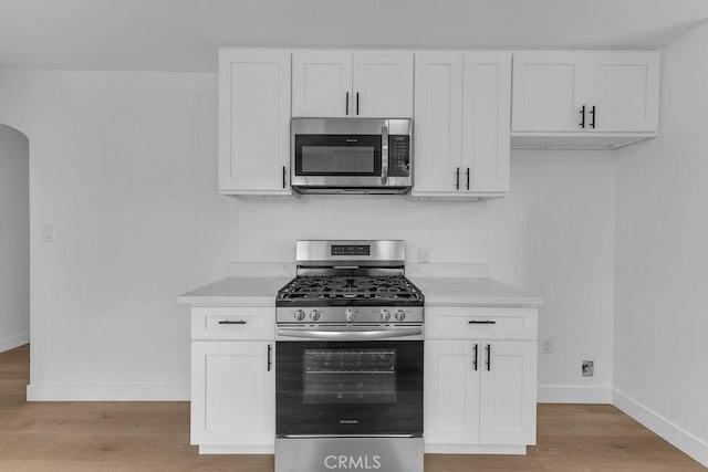 kitchen with white cabinetry, stainless steel appliances, and light hardwood / wood-style floors