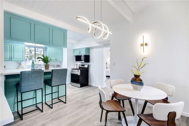 dining area with a notable chandelier and light hardwood / wood-style floors