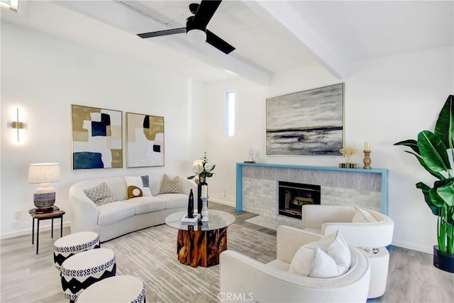 living room with hardwood / wood-style floors, beam ceiling, a fireplace, and ceiling fan