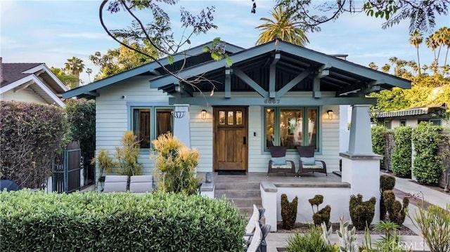 rear view of house featuring covered porch