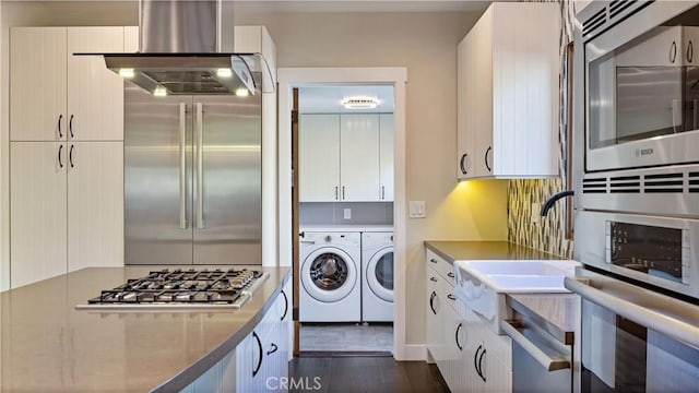 kitchen with separate washer and dryer, white cabinetry, dark hardwood / wood-style floors, and appliances with stainless steel finishes