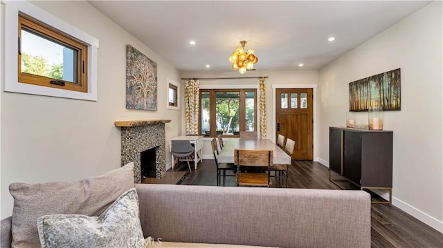 dining space featuring dark hardwood / wood-style floors, a fireplace, and a chandelier