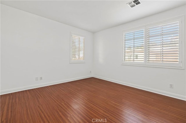 unfurnished room with hardwood / wood-style flooring and a wealth of natural light