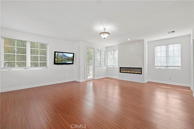 unfurnished living room featuring hardwood / wood-style floors and a large fireplace