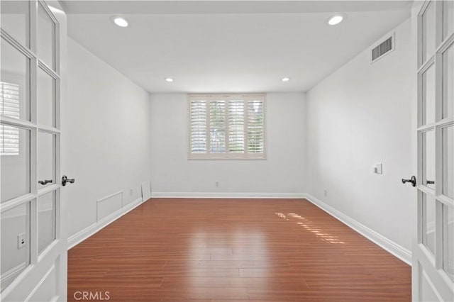 spare room with wood-type flooring