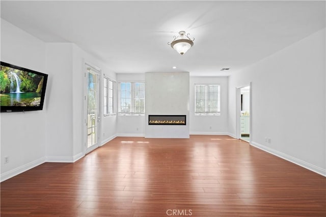 unfurnished living room with a large fireplace and wood-type flooring