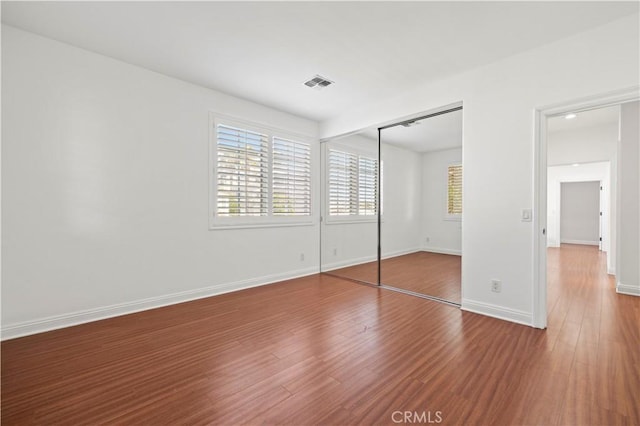 unfurnished bedroom with hardwood / wood-style floors and a closet