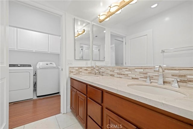 bathroom featuring tile patterned flooring, backsplash, vanity, and washer and dryer