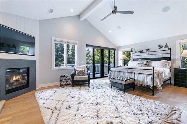 bedroom featuring high vaulted ceiling, access to outside, beamed ceiling, a fireplace, and hardwood / wood-style floors