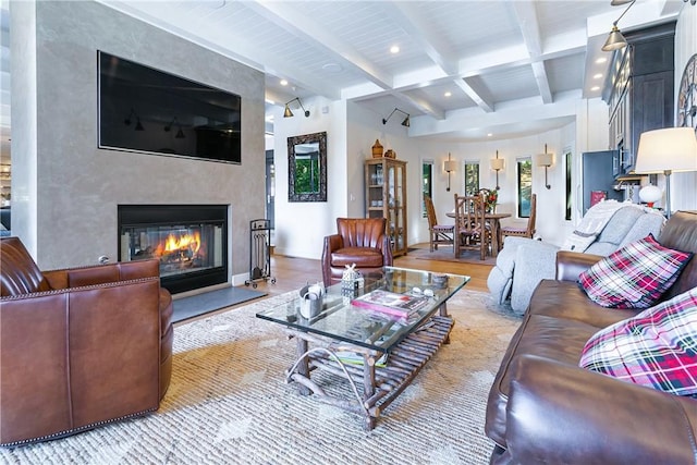 living room featuring beamed ceiling, a high end fireplace, and light wood-type flooring