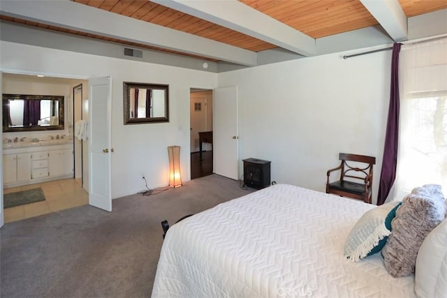 bedroom with wood ceiling, beam ceiling, ensuite bath, and carpet