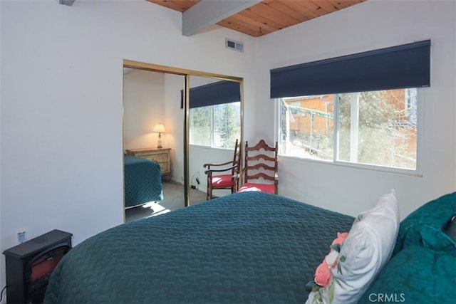 carpeted bedroom featuring beamed ceiling, wood ceiling, and a closet