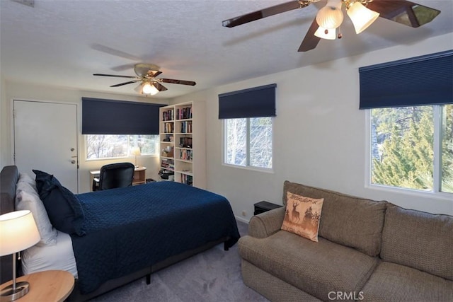 carpeted bedroom featuring ceiling fan and multiple windows