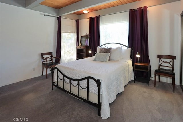 carpeted bedroom with beamed ceiling and wood ceiling