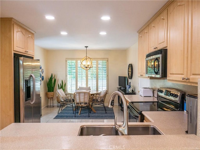 kitchen featuring stainless steel appliances, decorative light fixtures, and light brown cabinetry