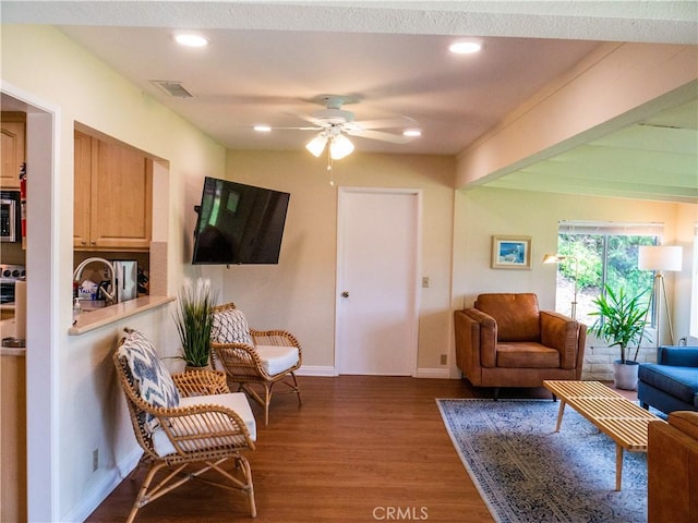 living room with sink, dark wood-type flooring, and ceiling fan