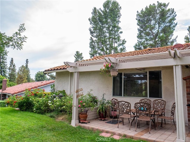 back of property featuring a yard, a pergola, and a patio