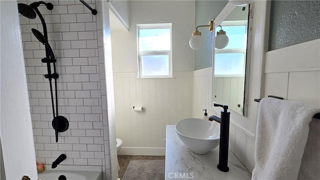 full bathroom featuring sink, toilet, and tiled shower / bath