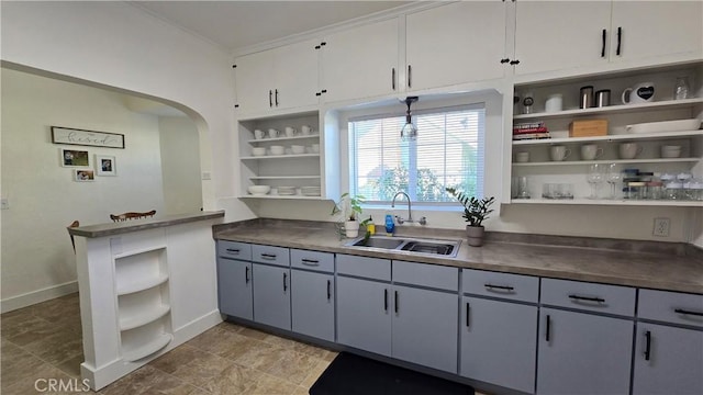 kitchen featuring ornamental molding, sink, and white cabinets