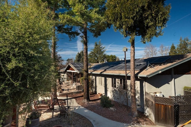 back of house featuring solar panels