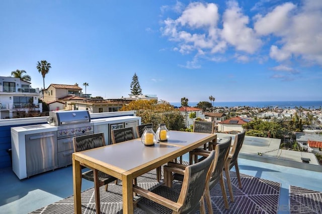 view of patio / terrace with a water view, a grill, and exterior kitchen