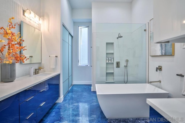 bathroom featuring vanity, backsplash, and independent shower and bath