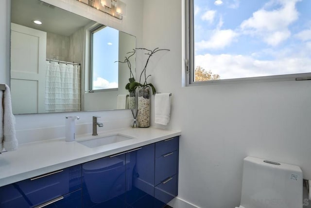 bathroom featuring a shower with curtain, vanity, and toilet