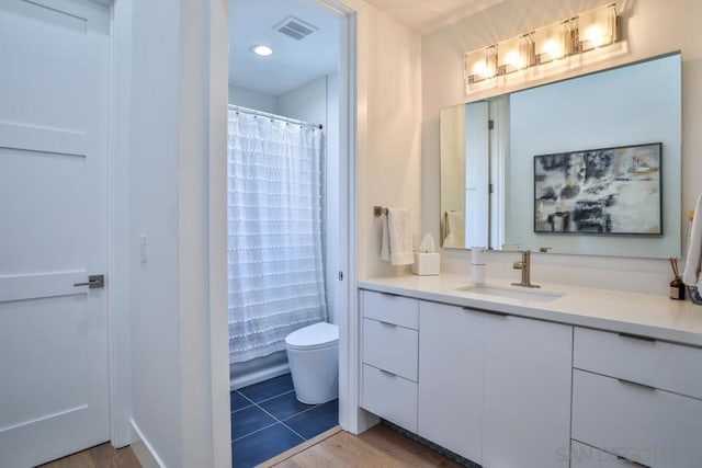 bathroom with hardwood / wood-style flooring, vanity, and toilet