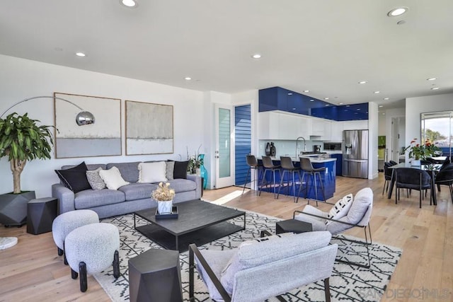 living room featuring sink and light hardwood / wood-style floors