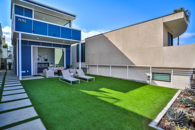 back of house featuring outdoor lounge area and a lawn