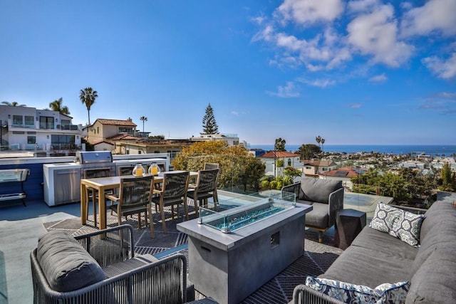 view of patio / terrace featuring an outdoor living space with a fire pit and a water view