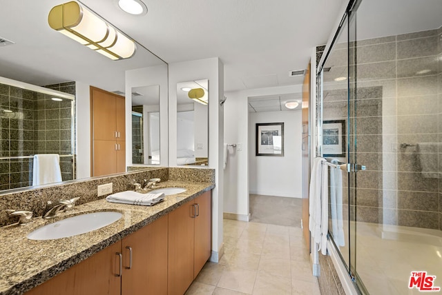 bathroom with vanity, tile patterned floors, and bath / shower combo with glass door