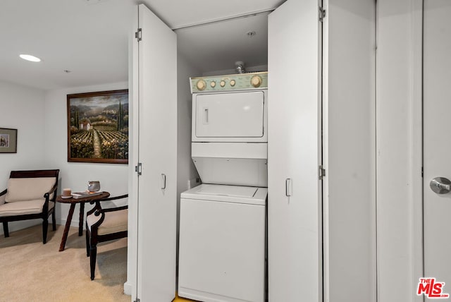 laundry area featuring light colored carpet and stacked washer / drying machine