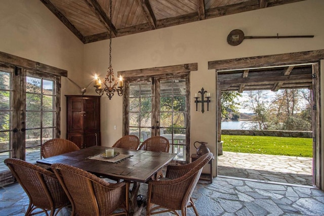 dining space featuring french doors, a wealth of natural light, a water view, wood ceiling, and beamed ceiling