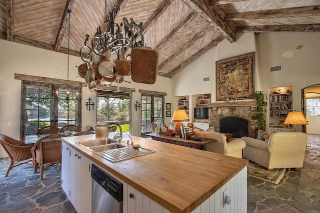 kitchen with a sink, wood ceiling, white cabinets, and stainless steel dishwasher