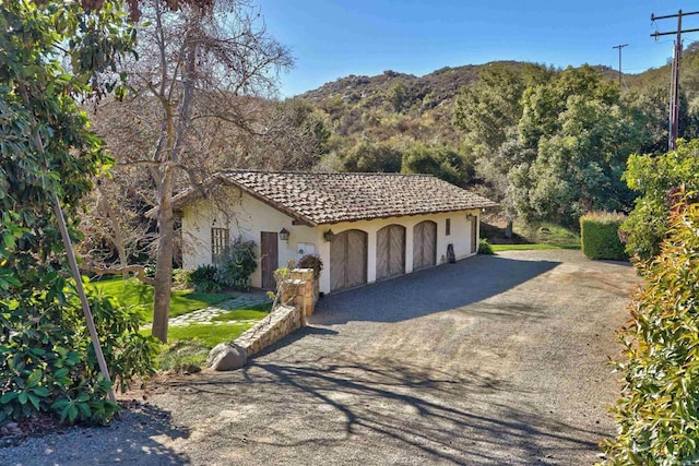 view of front of home featuring stucco siding, a mountain view, and a tiled roof